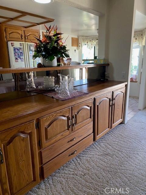 kitchen with light carpet, white fridge, and wood counters