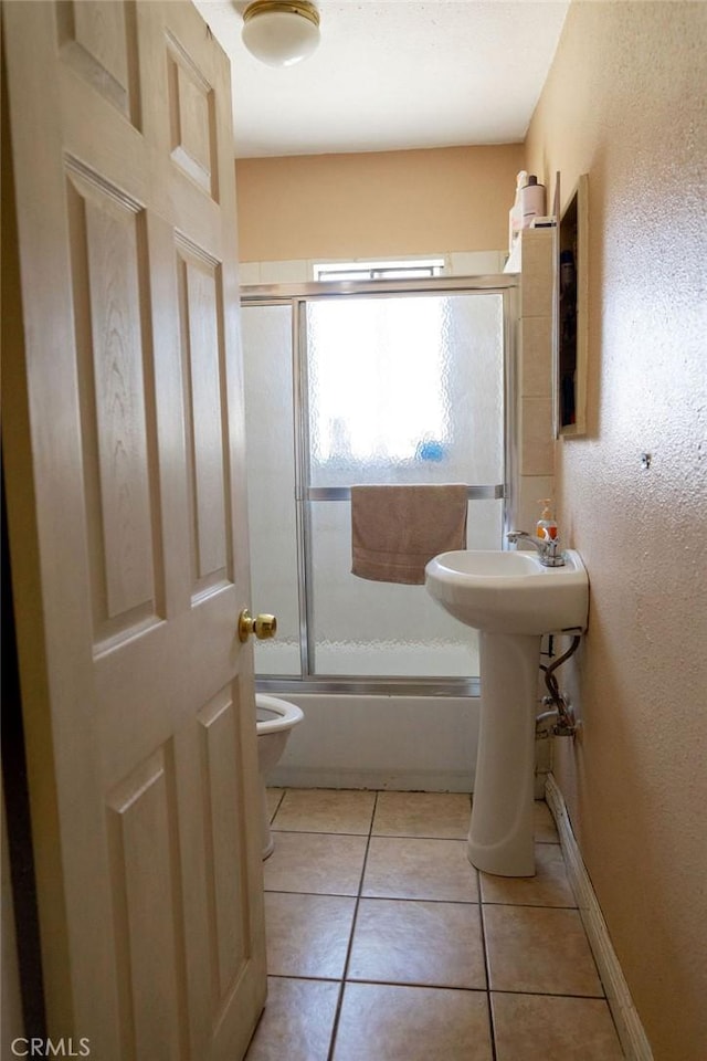 bathroom with tile patterned flooring, enclosed tub / shower combo, and toilet