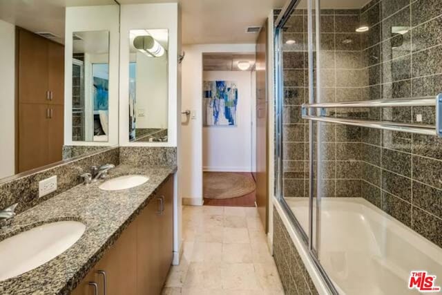 bathroom with combined bath / shower with glass door, tile patterned floors, and double vanity