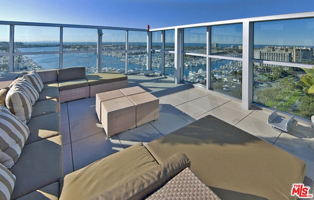 view of patio / terrace with a balcony, a water view, and an outdoor living space