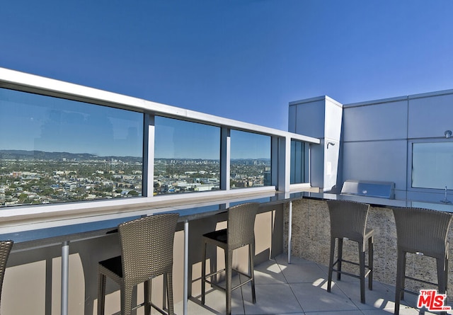 balcony with area for grilling and exterior bar