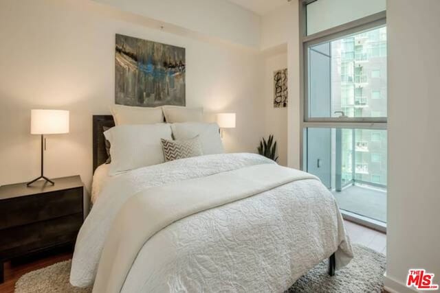 bedroom featuring access to outside, hardwood / wood-style floors, and multiple windows