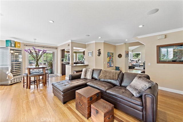 living room with light hardwood / wood-style flooring, wine cooler, and ornamental molding