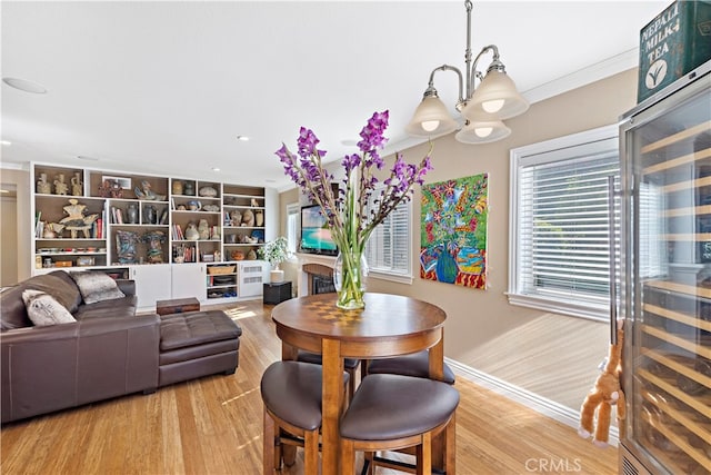 dining space featuring wood-type flooring, a notable chandelier, and crown molding