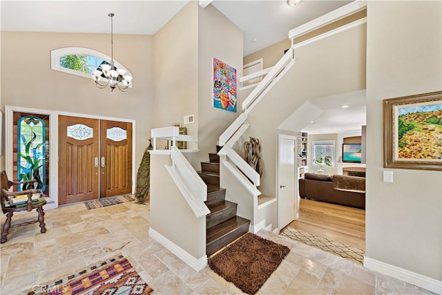 foyer featuring a notable chandelier and high vaulted ceiling