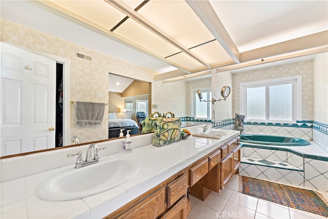 bathroom featuring tiled tub, vanity, lofted ceiling, and tile patterned floors