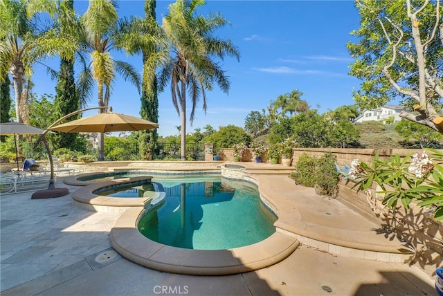 view of swimming pool featuring a patio and an in ground hot tub