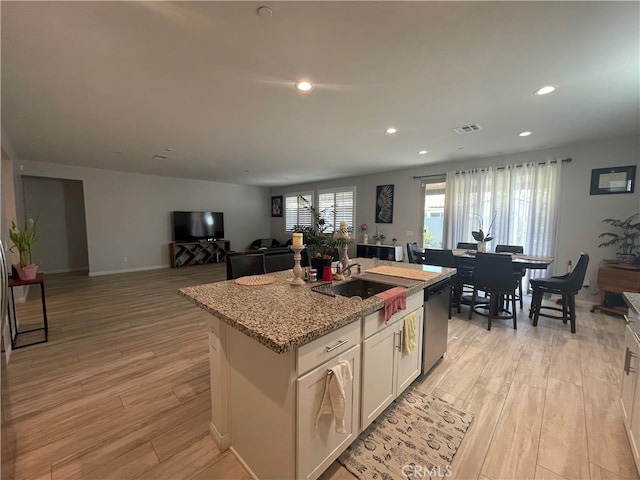 kitchen with white cabinets, light hardwood / wood-style floors, and a healthy amount of sunlight