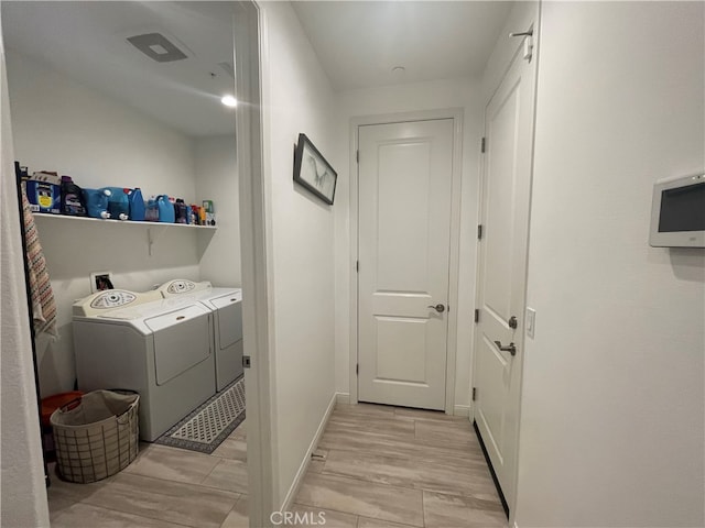 laundry area with light hardwood / wood-style floors and washer and dryer