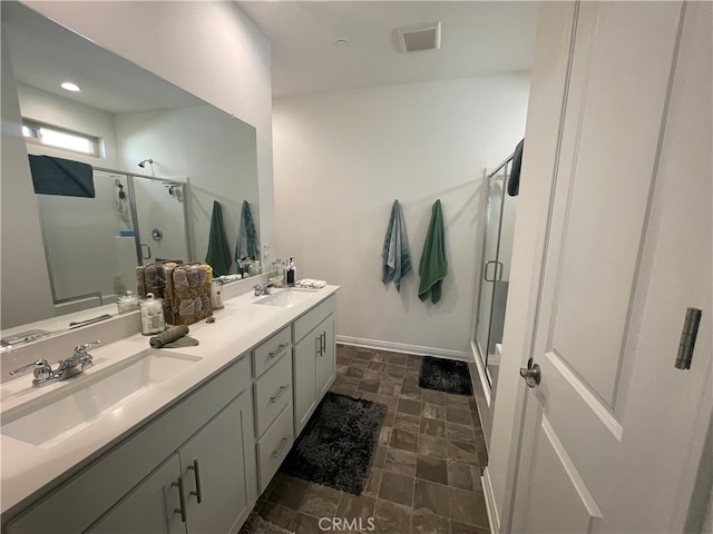 bathroom featuring double sink vanity, walk in shower, and tile patterned floors