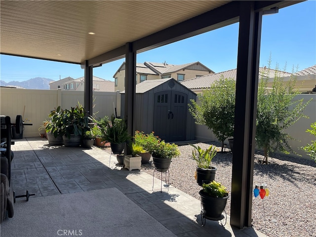 view of patio / terrace featuring a storage unit and a mountain view