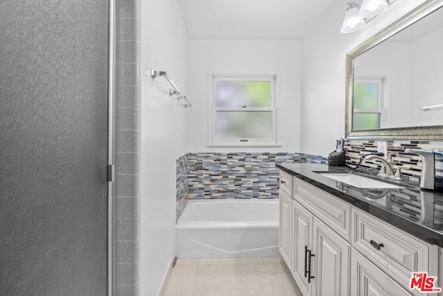 bathroom featuring a bathtub, tile patterned flooring, decorative backsplash, and vanity