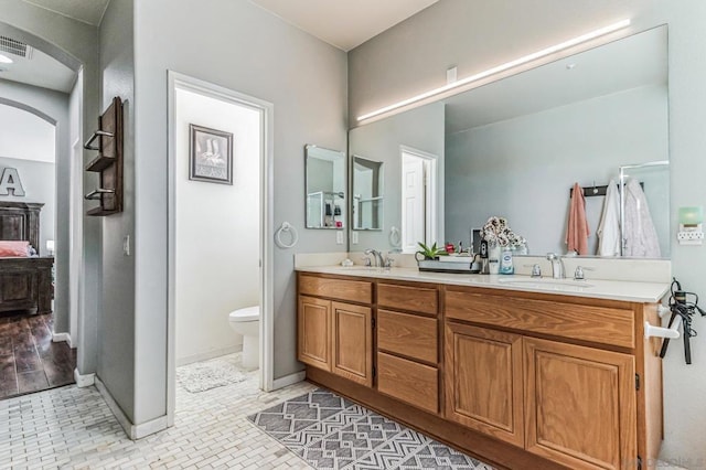 bathroom featuring toilet, vanity, and tile patterned floors