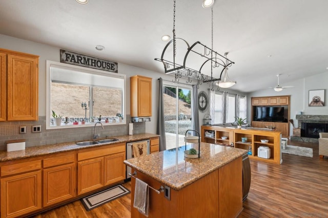 kitchen featuring lofted ceiling, a kitchen island, dark hardwood / wood-style flooring, sink, and ceiling fan