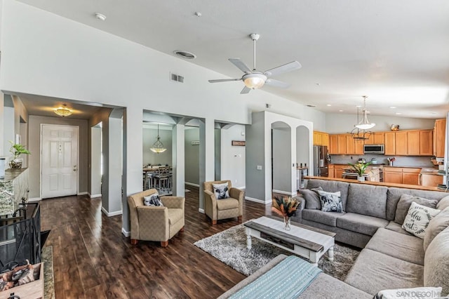 living room featuring vaulted ceiling, ceiling fan, and dark hardwood / wood-style flooring