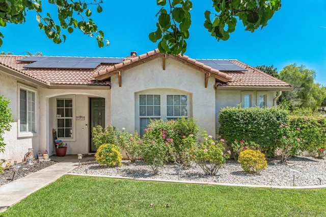 view of front of home featuring a front yard and solar panels