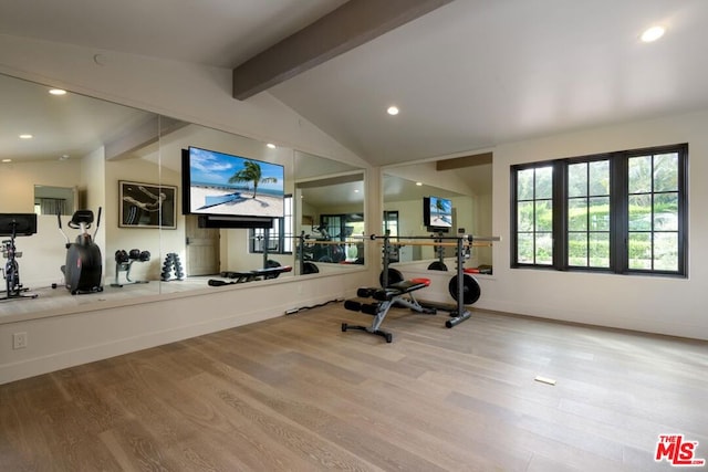 workout area with light hardwood / wood-style flooring and vaulted ceiling