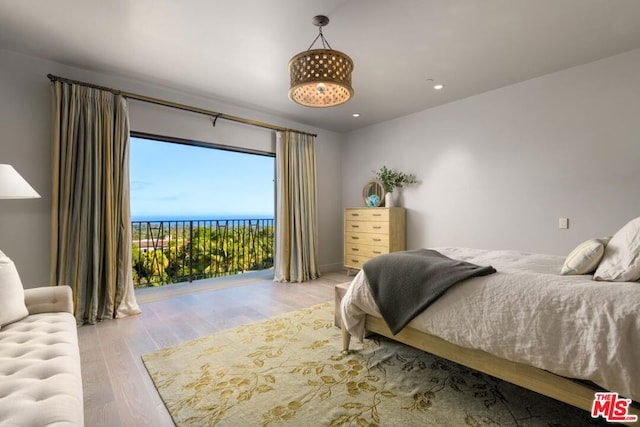 bedroom with light wood-type flooring and access to outside