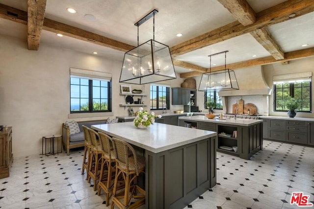 kitchen featuring beamed ceiling, gray cabinets, pendant lighting, and a center island