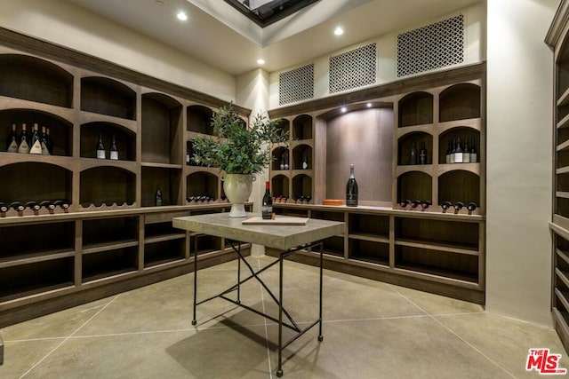 wine cellar with light tile patterned floors and a towering ceiling