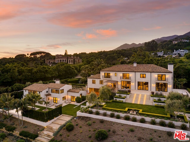 aerial view at dusk featuring a mountain view