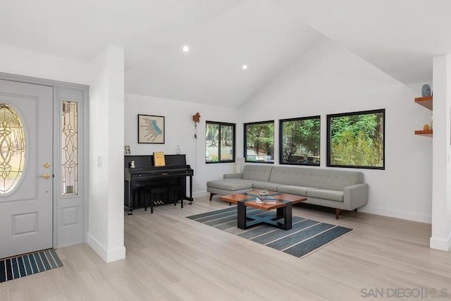 living room featuring high vaulted ceiling and light wood-type flooring