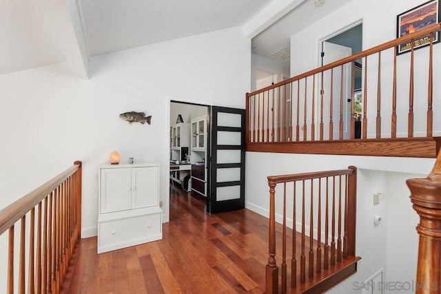 stairs featuring hardwood / wood-style floors and beamed ceiling