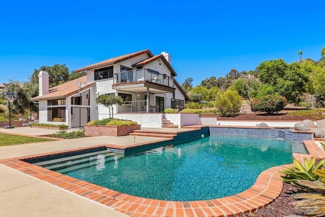 rear view of property with a patio area and a balcony