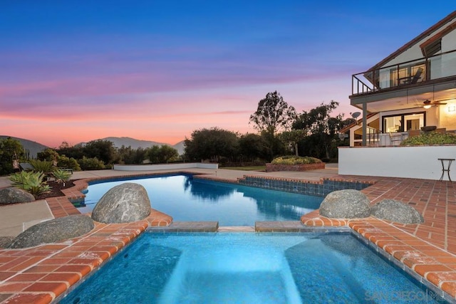 pool at dusk featuring a mountain view