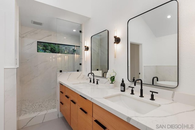 bathroom with vanity, tile patterned flooring, and tiled shower