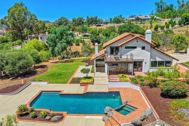 view of pool with an in ground hot tub, a patio area, and a lawn