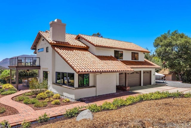 rear view of property featuring a garage and a balcony