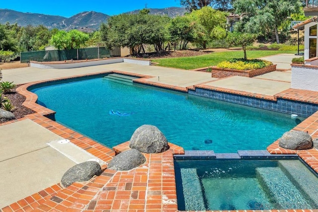 view of swimming pool featuring a mountain view and an in ground hot tub