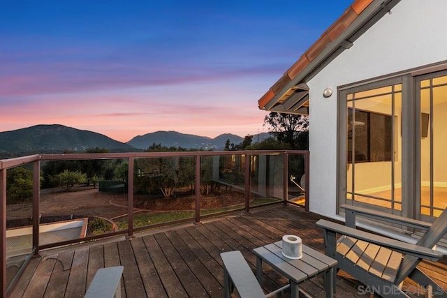 deck at dusk featuring a mountain view