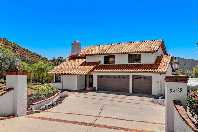 mediterranean / spanish-style home featuring a mountain view and a garage