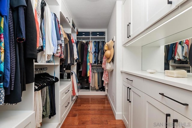 spacious closet with dark hardwood / wood-style flooring