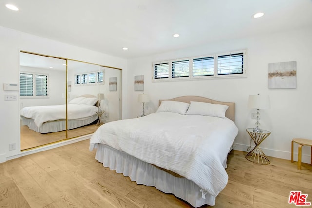 bedroom with light wood-type flooring and a closet