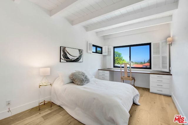 bedroom featuring beam ceiling and light hardwood / wood-style floors