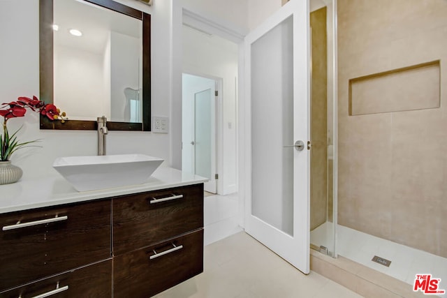 bathroom with vanity and a tile shower