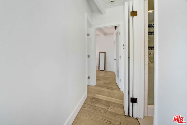 hallway with light hardwood / wood-style flooring and beamed ceiling