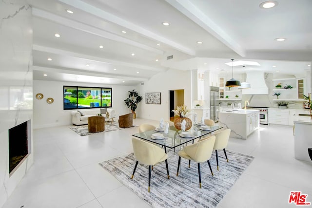 tiled dining space featuring beamed ceiling and sink