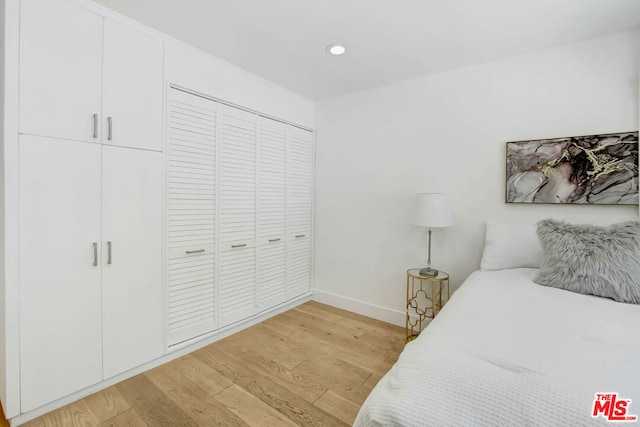 bedroom featuring light wood-type flooring and a closet