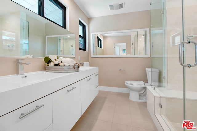 bathroom featuring tile patterned floors, vanity, toilet, and an enclosed shower