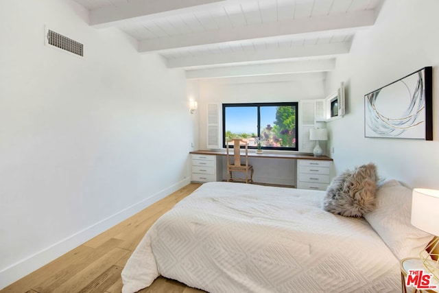 bedroom featuring hardwood / wood-style flooring and beamed ceiling