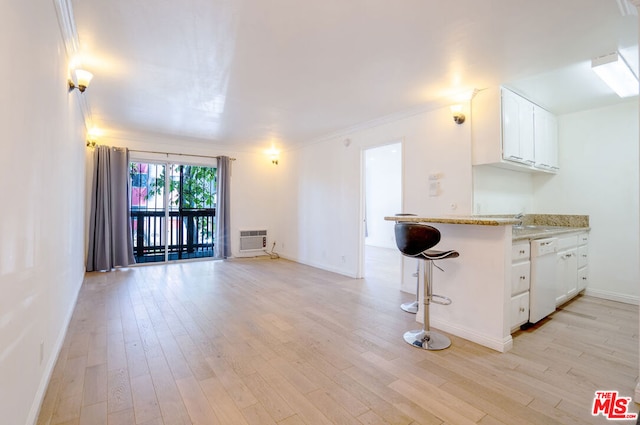 kitchen featuring white cabinets, dishwasher, light wood-type flooring, kitchen peninsula, and a breakfast bar