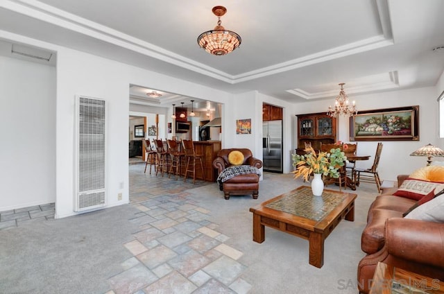 living room featuring a raised ceiling, light carpet, and a notable chandelier