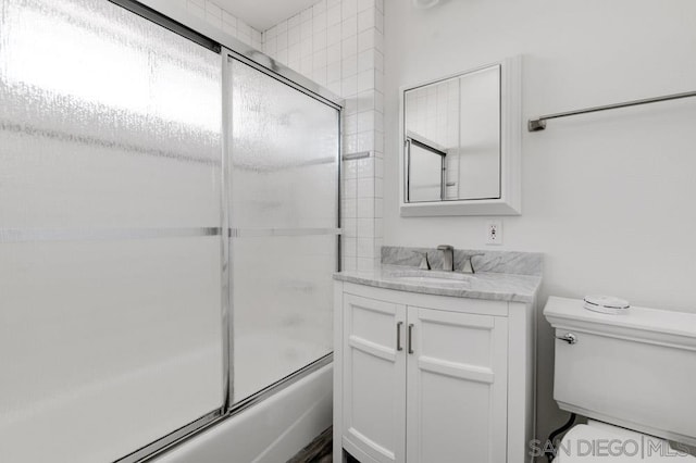 full bathroom featuring shower / bath combination with glass door, vanity, and toilet