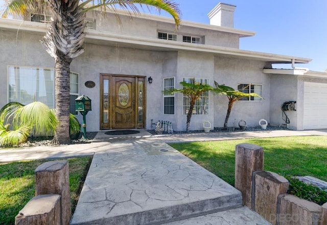 property entrance featuring a garage and a yard