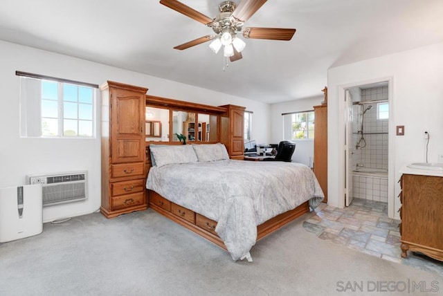 bedroom with ceiling fan, light colored carpet, ensuite bath, and an AC wall unit