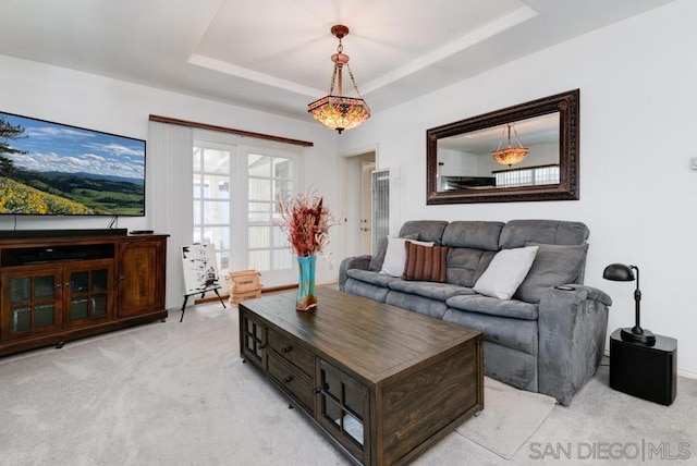 carpeted living room featuring a tray ceiling